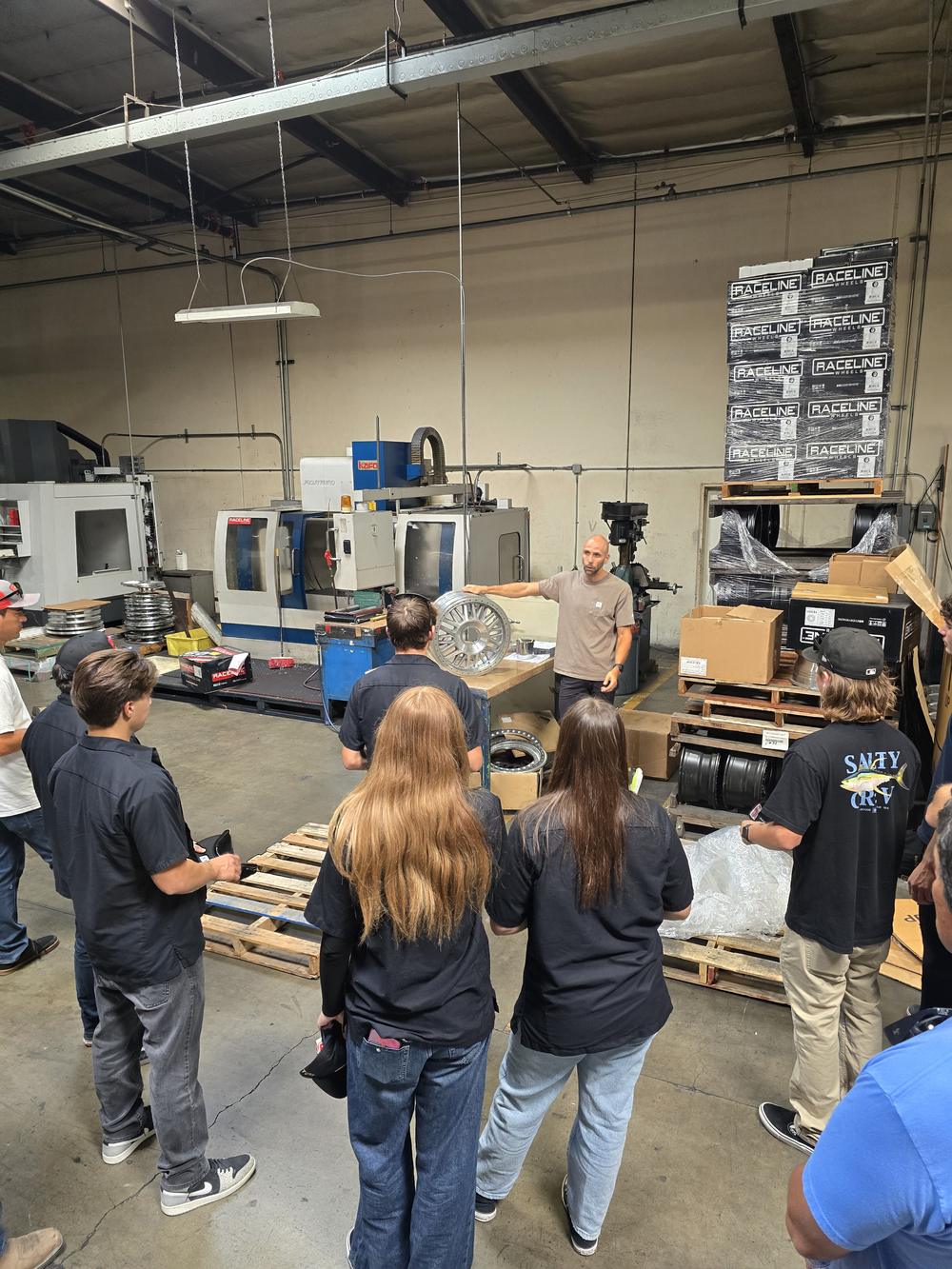 Students touring the CNC machine shop at Raceline Wheels