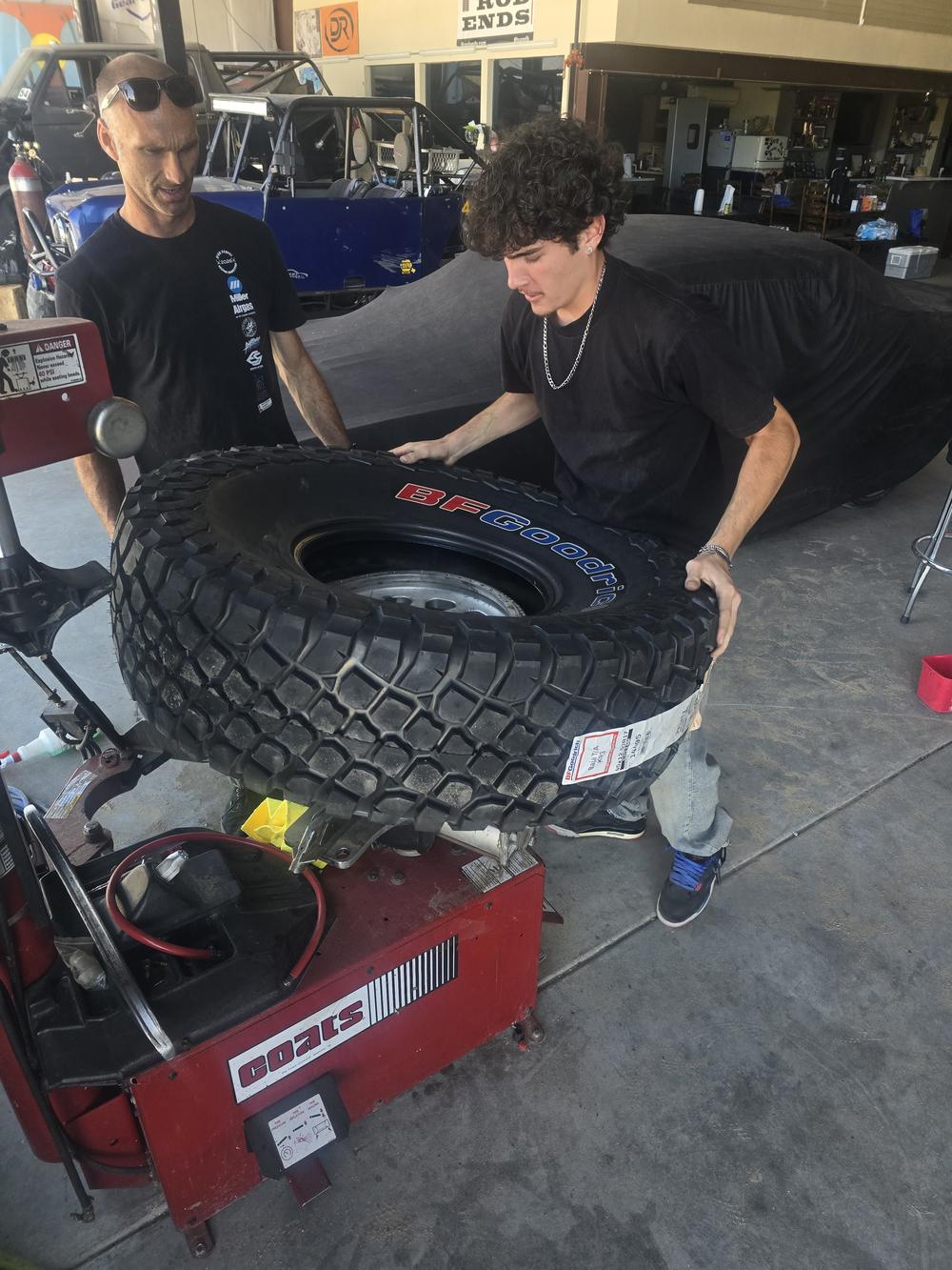 Students mounting a race tire on a tire machine