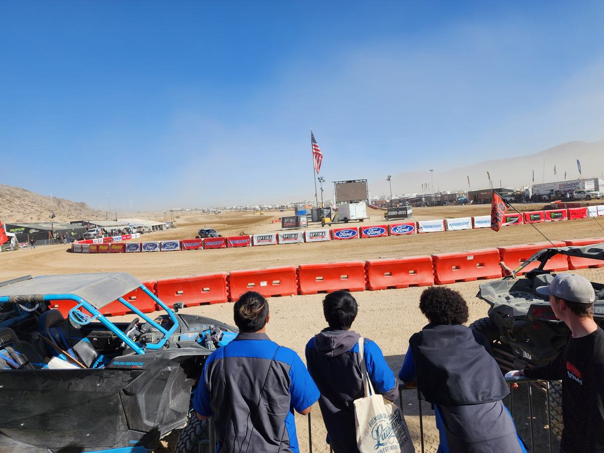 Students at the start line barriers watching race vehicles